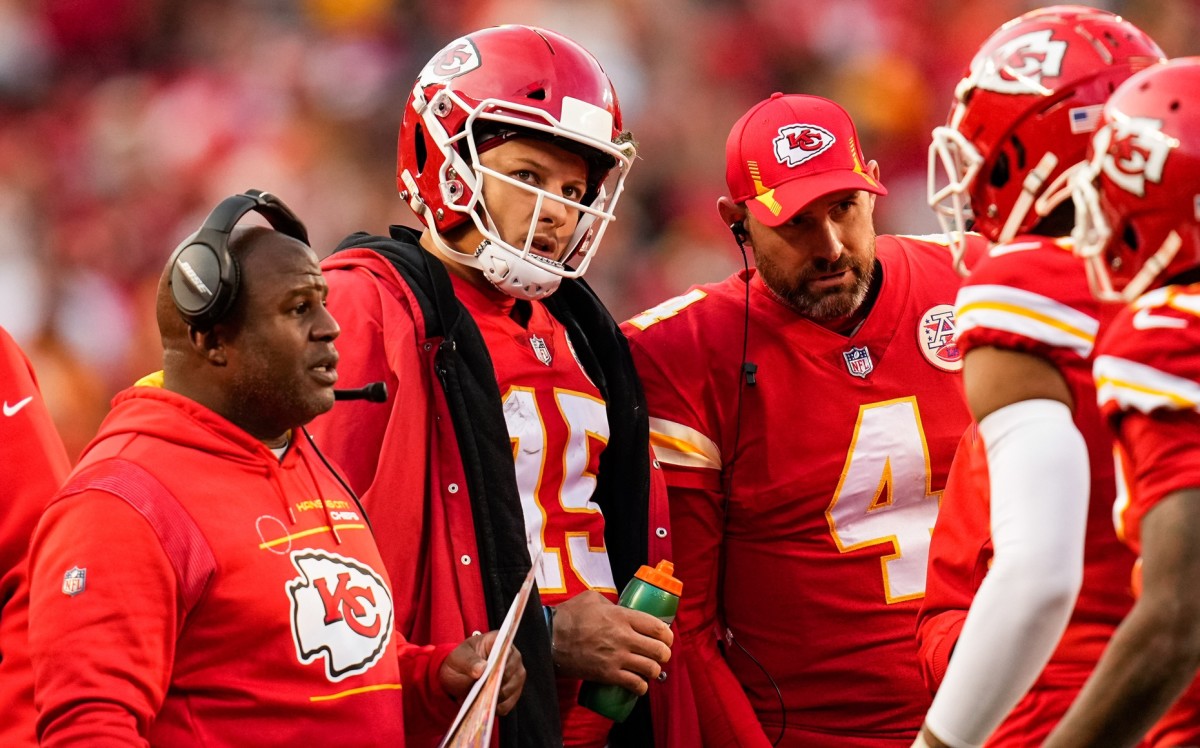 Jan 30, 2022; Kansas City, Missouri, USA; Kansas City Chiefs quarterback Patrick Mahomes (15) huddles with offensive coordinator Eric Bieniemy and quarterback Chad Henne (4) during a timeout in the second half of the AFC Championship game against the Cincinnati Bengals at GEHA Field at Arrowhead Stadium. Mandatory Credit: Jay Biggerstaff-USA TODAY Sports